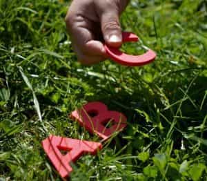 red-letters-in-grass-with-human-hand
